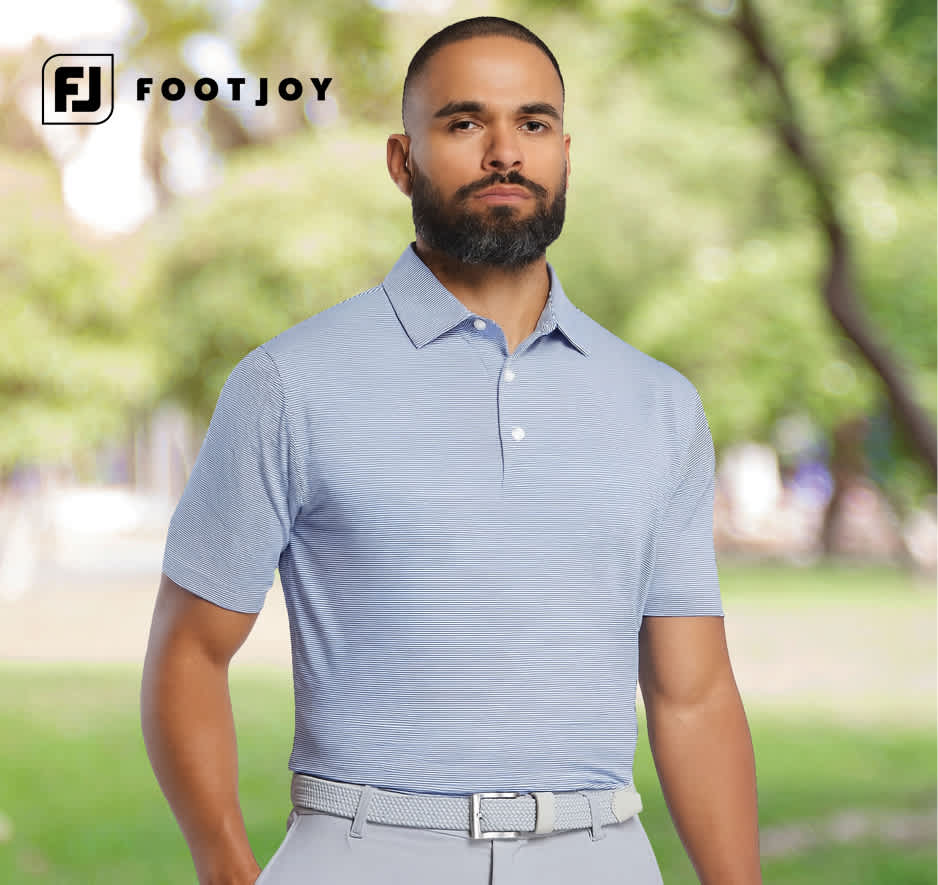 Man wearing a light blue FootJoy golf polo outdoors