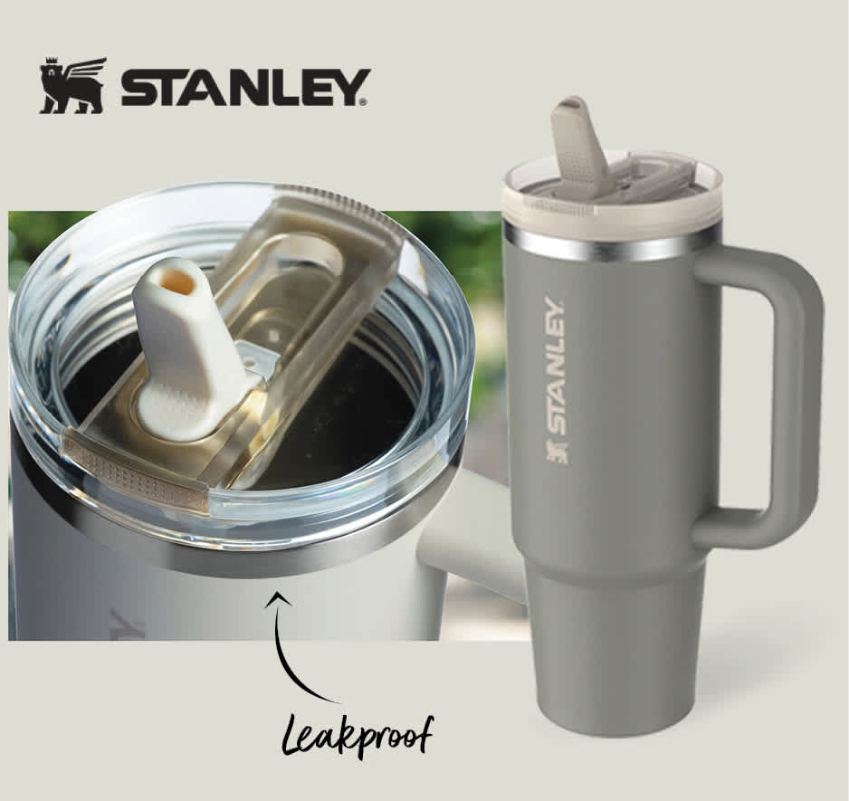 Stanley grey travel tumbler with handle and flip straw lid.